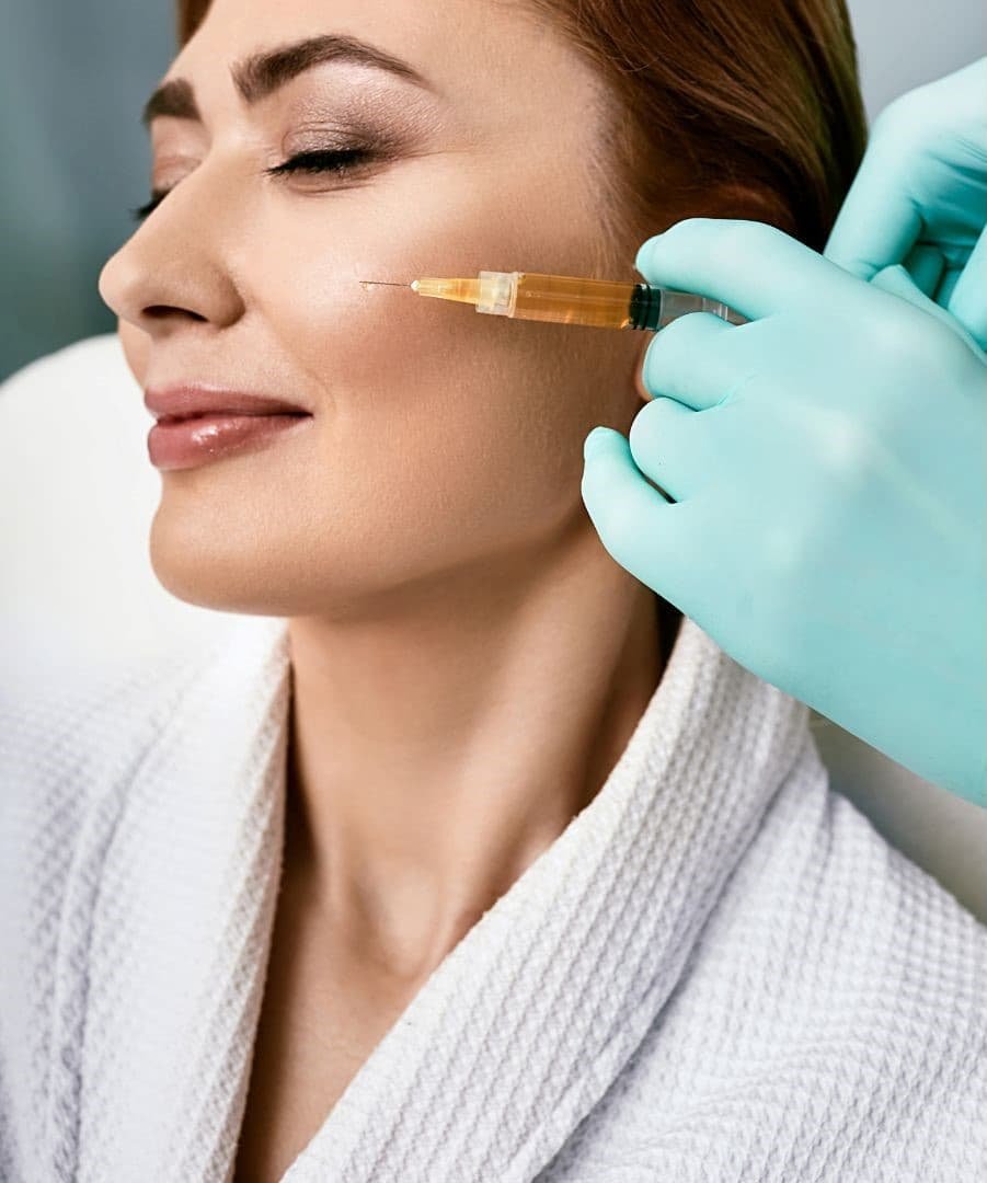 Woman receiving Platelet Rich Plasma (PRP) injection for skin rejuvenation, with clinician's gloved hand administering treatment, highlighting aesthetic medicine benefits.