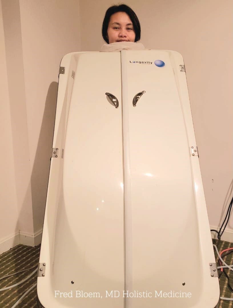 Ozone sauna therapy session with a person in a Longevity sauna unit, promoting wellness and detoxification.