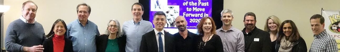 Group of professionals at a wellness event, discussing peptide treatments and holistic health, with a presentation backdrop highlighting advancements in skincare and health optimization.